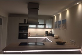 Deckenprofile aus Hartschaum für die direkte Beleuchtung der Wand und Arbeitsplatte in einer Küche.